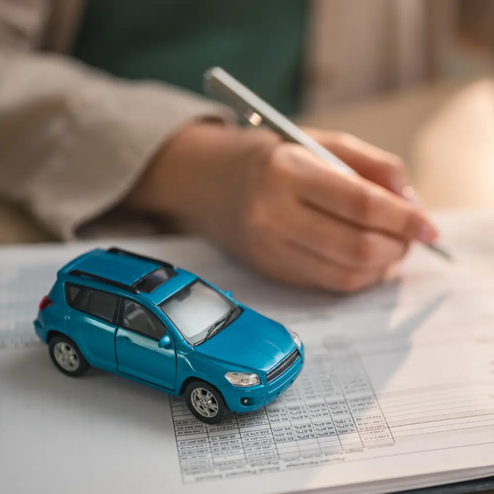 Miniature de voiture et documents financiers Modèle réduit de voiture sur documents financiers.
