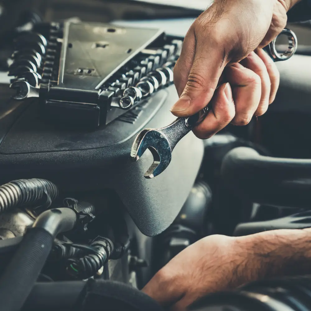 Entretien automobile | BC AUTO Mécanicien utilisant une clé sur un moteur