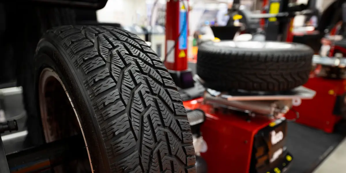 Pneu en atelier : sécurité et performance | BC AUTO Pneu avec motif de bande de roulement en gros plan dans un atelier.